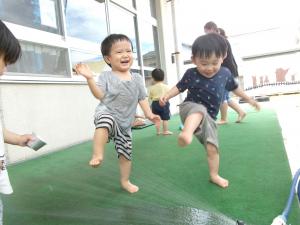 ホースの水を見て興奮して足を上げる1歳児