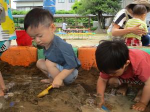 泥んこ遊びをする2歳児