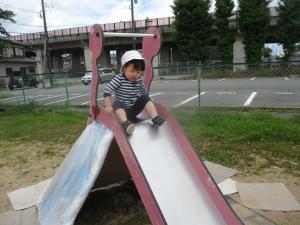 すべり台をすべってみようとする１歳児