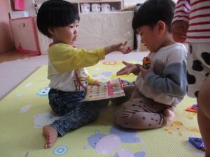 メニュー表を見てアイスをどうぞと渡す真似をする２歳児