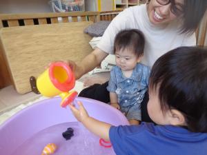 部屋で水遊びする０歳児