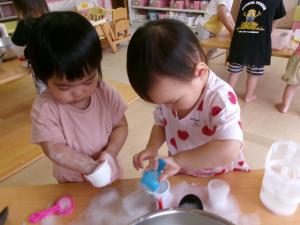 せっけんの泡で遊ぶ1歳児