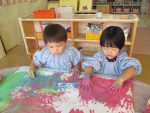 フィンガーペイントを楽しむ２歳児