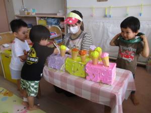 アイスクリーム屋さんごっこをする２歳児