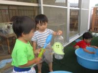水鉄砲でおばけの的に当てようとする２歳児