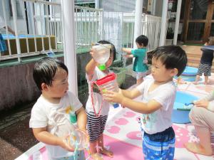ペットボトルで作ったジョーロで遊ぶ2歳児