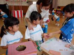 おまつりごっこでくじびきをする4歳児