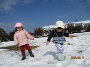 雪の感触を確かめるように踏みしめる1歳児