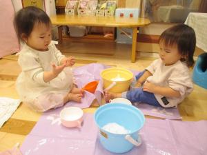 保育室で雪に触れてみる0歳児