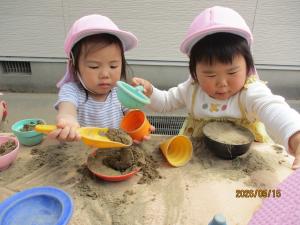 砂遊びをする2歳児